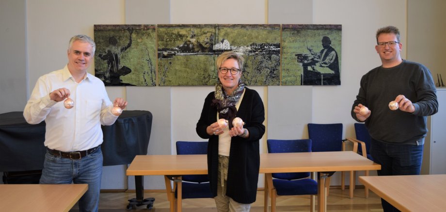 Bürgermeister Dr. Bastian, Monika Weber der SeligenStadtMarketing GmbH und Erster Stadtrat Michael Gerheim stellen die Seligenstädter Christbaumkugel 2020 vor