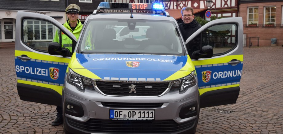 Erster Stadtrat Gerheim mit einem Ordnungspolizisten im Dienst am neuen Auto