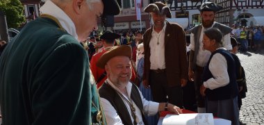 Peter Rühl vom AK Kaufmannszug trägt sich in das Goldene Buch der Stadt ein