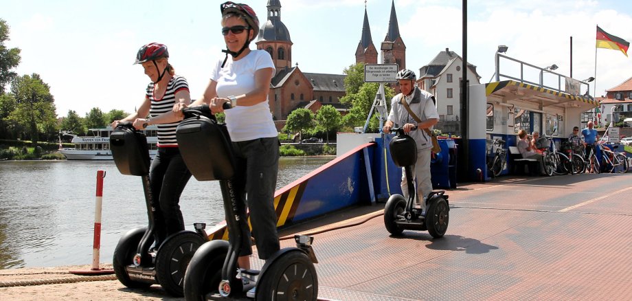 Menschen auf Segways an der Seligenstädter Fähre