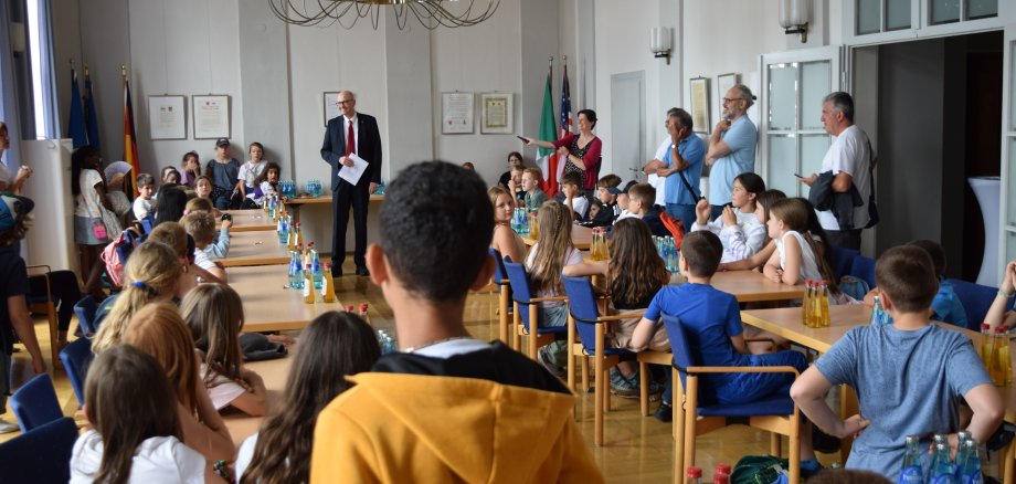 Stadtverordnetenvorsteher Dr. Richard Georgi begrüßt die Kinder im großen Sitzungssaal des Rathauses