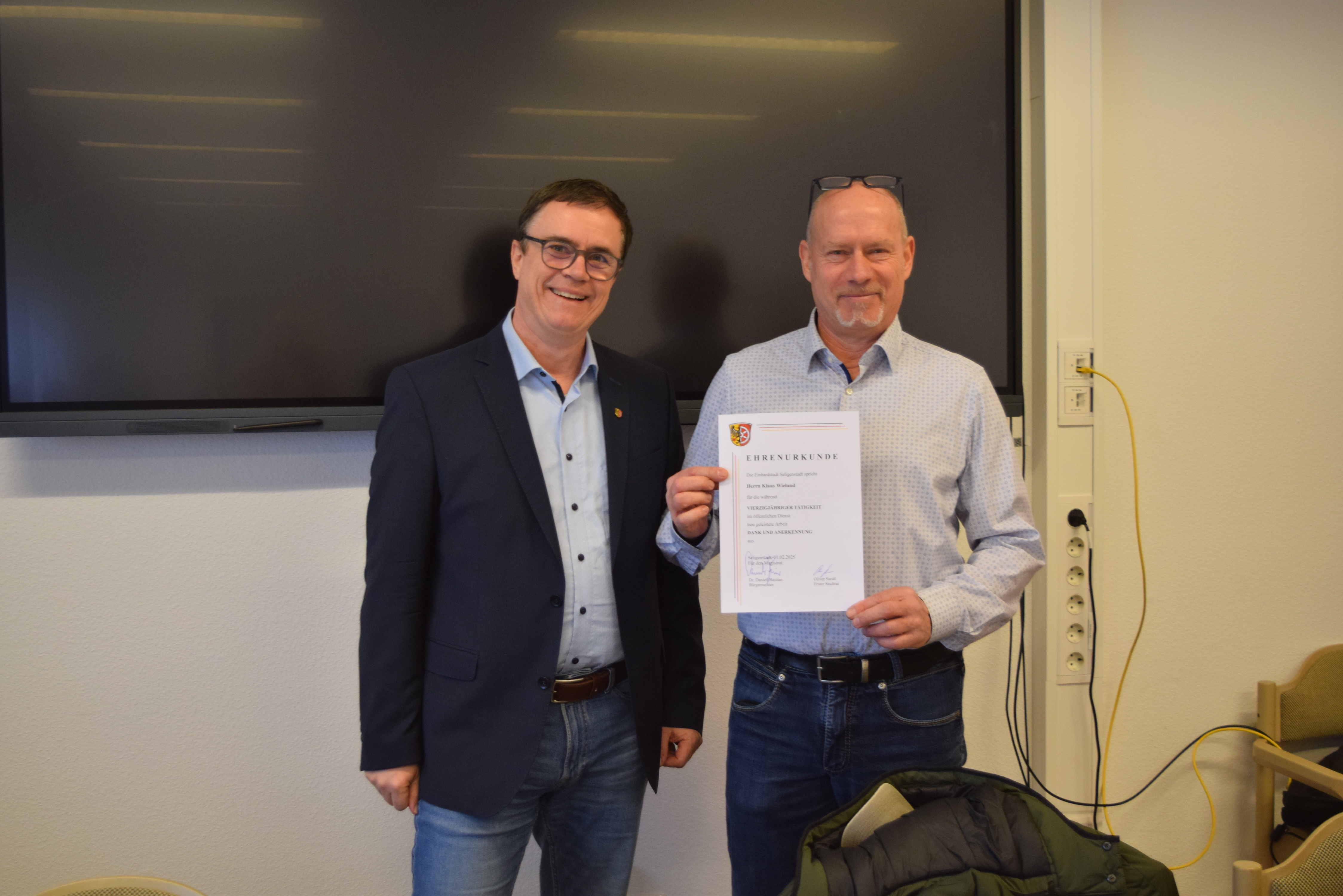 Bürgermeister Dr. Bastian bedankt sich bei Klaus Wieland mit einer Urkunde und einem Geschenk