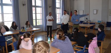 Ali Mediouni vom efs, Erster Stadtrat Oliver Steidl und Bürgermeister Dr. Daniell Bastian mit der Jugendgruppe im Rathaus