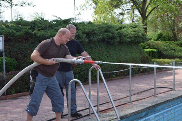 Mitarbeiter des Schwimmbades beim Reinigen der Becken Mitarbeiter des Schwimmbades beim Reinigen der Becken