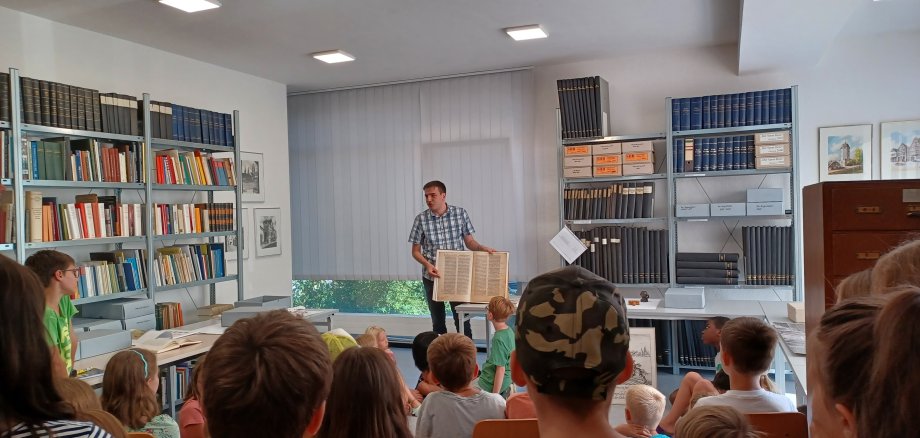 Archivleiter Matthias Lorenz mit den Schülerinnen und Schülern der Alfred-Delp-Grundschule