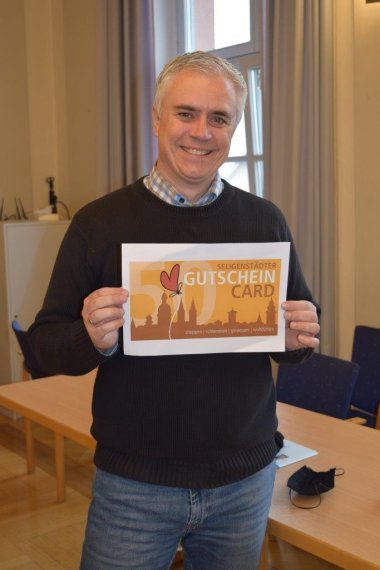 Bürgermeister Dr. Bastian mit der Aktions-Gutschein Card des Gewerbevereins über 50 Euro
