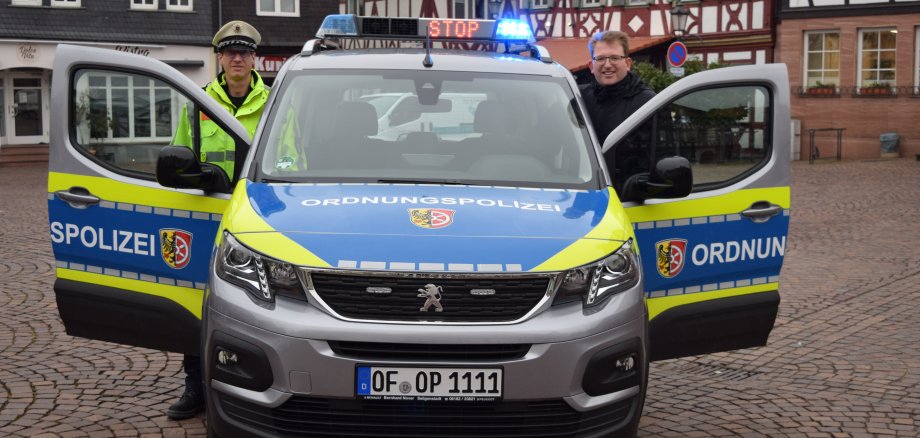 Erster Stadtrat Gerheim mit einem Ordnungspolizisten im Dienst am neuen Auto
