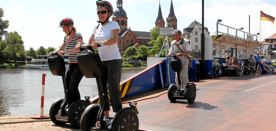 Menschen auf Segways an der Seligenstädter Fähre