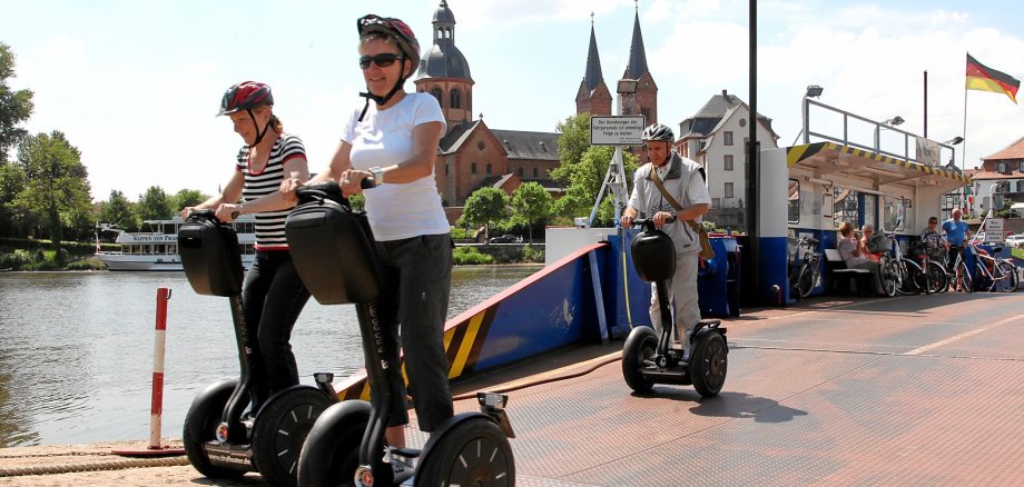 Menschen auf Segways an der Seligenstädter Fähre