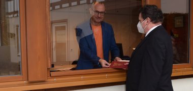 Standesamtsschalter zu Corona Zeiten Bestatter und Urkundenabholer werden, wenn es geht, über das offene Fenster durch eine Glasscheide bedient, Standesamtsschalter zu Corona Zeiten von außen