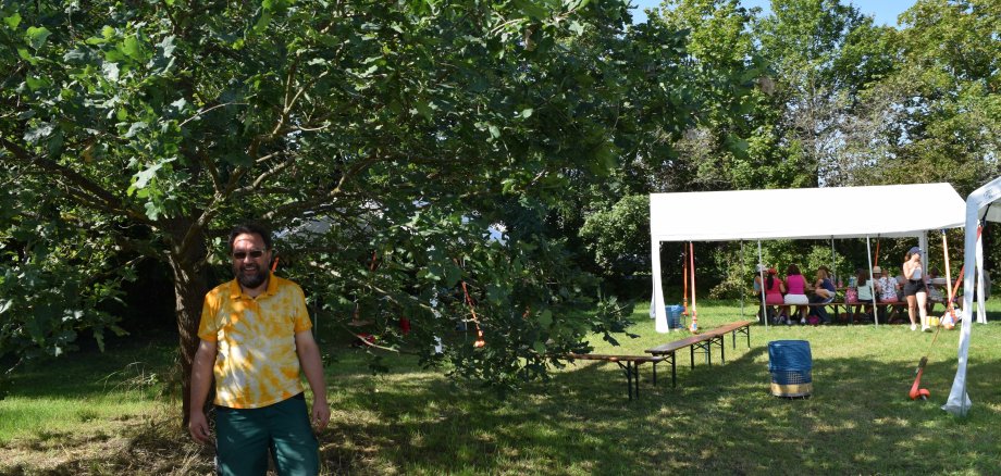 Amtsleiter Tom Heilos unter der von ihm gepflanzten Eiche auf dem Gelände der städtischen Ferienspiele 2023