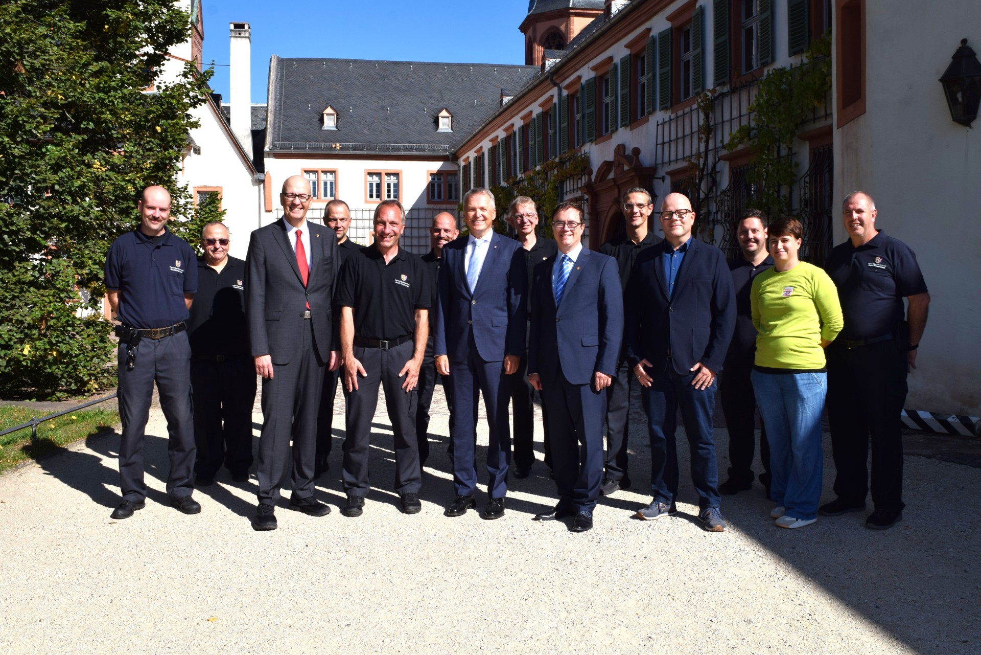 von links nach rechts vorne: Einsatzleiter Dr. Richard Georgi, Stadtbrandinspektor Alexander Zöller, Staatsminister Martin Rößler, Bürgermeister Dr. Daniell Bastian, stellv. Direktor Staatliche Schlösser und Gärten Hessen Volker Gilbert, Leiterin des Gartens und der Außenstelle Jana Lühring. Um die genannten Personen herum stehen ehrenamtliche und hauptamtliche Feuerwehrleute.